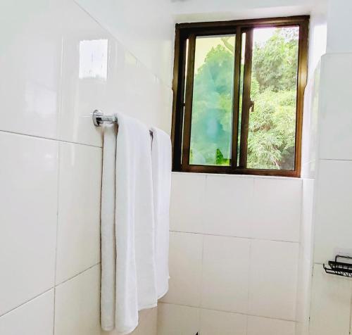 a bathroom with a window and a towel at AWESOME HOME's in Arusha
