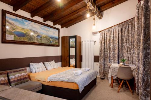 a bedroom with a bed and a table in it at Студио Мурите in Sapareva Banya
