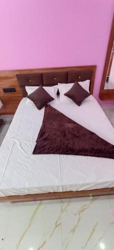 a large bed with white sheets and black pillows at Shri Goara palece in Godarpura