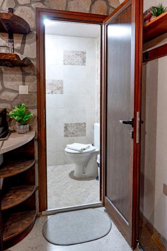 a bathroom with a toilet and a glass door at Студио Мурите in Sapareva Banya