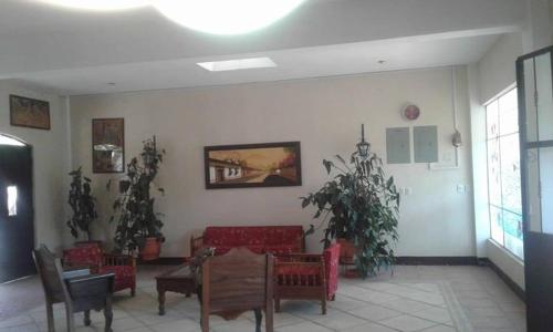 ein Wohnzimmer mit roten Stühlen und einem Tisch in der Unterkunft La Chacra de Joel Hotel in Huehuetenango