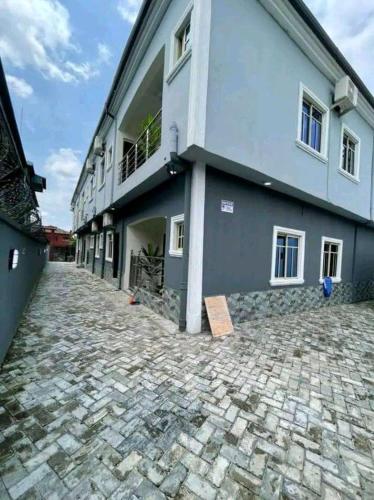 a building on a cobblestone street in front of a building at Beatrice apartment services in Warri