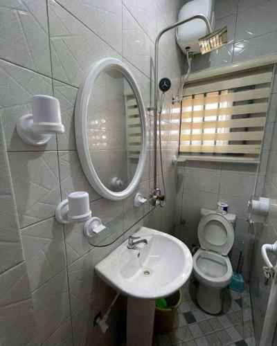 a bathroom with a sink and a mirror and a toilet at Beatrice apartment services in Warri