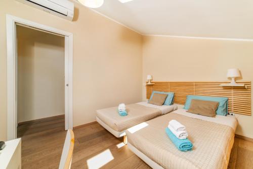 two beds in a small room with blue pillows at B&B Portanova in Salerno