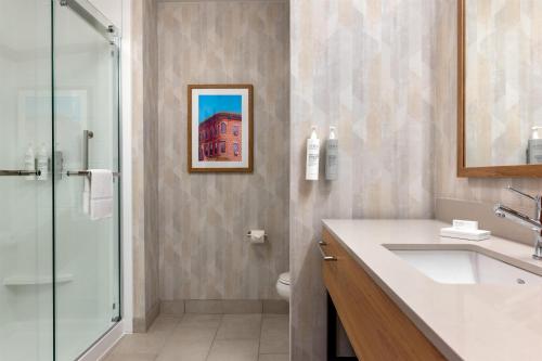 a bathroom with a shower and a sink and a toilet at Hampton Inn & Suites Rockland in Thomaston