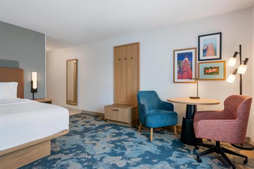 a hotel room with a bed and two chairs and a table at Hampton Inn & Suites Rockland in Thomaston