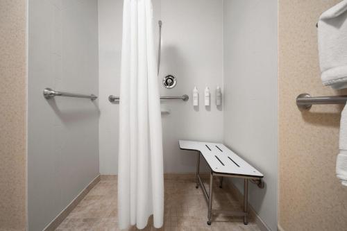 a bathroom with a white shower curtain next to a sink at Hampton Inn Winfield Teays Valley in Teays Valley Estates