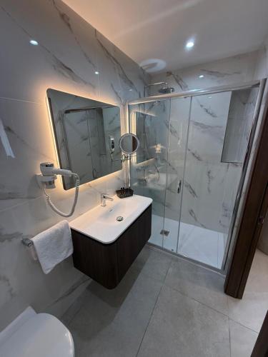 a bathroom with a shower and a sink and a toilet at Grand Harbour Hotel in Valletta