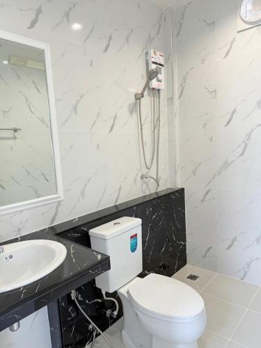 a bathroom with a toilet and a sink at โรงแรม นีโอ รีสอร์ท in Ban Thap Nang