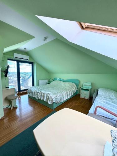 a attic bedroom with two beds and a window at Albatros in Chełm