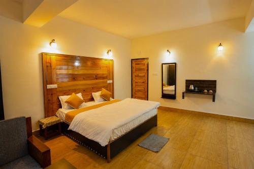 a bedroom with a large bed with a wooden headboard at Twin Garden by TAPSOM in Tādong