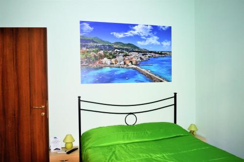 Un dormitorio con una cama verde con una foto en la pared en Napoli Station B&B, en Nápoles