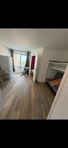 an empty room with a bed and a wooden floor at Appartement Ipanema Sud in Canet-en-Roussillon