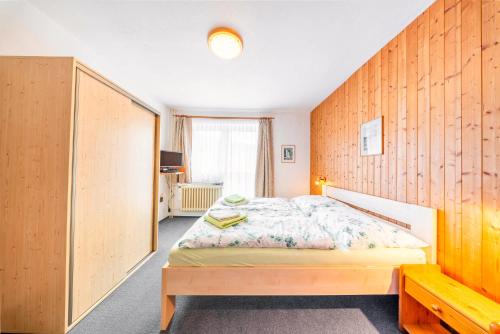 a bedroom with a bed and a wooden wall at Pension Kubát in Špindlerův Mlýn