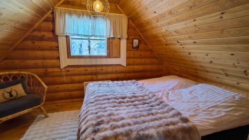 a bedroom with a bed and a window in a log cabin at Vähäreinari, mökki Ylläksellä in Ylläsjärvi