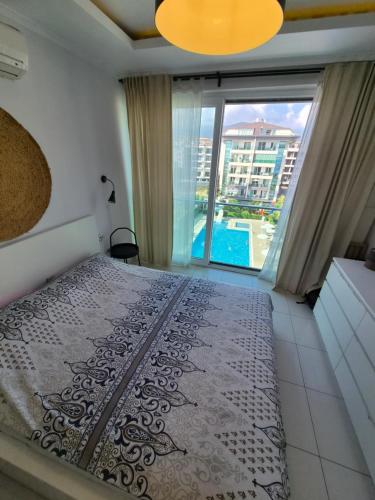 a bedroom with a bed and a large window at WEDAT APART On the beach Moda Marine Residence in Alanya