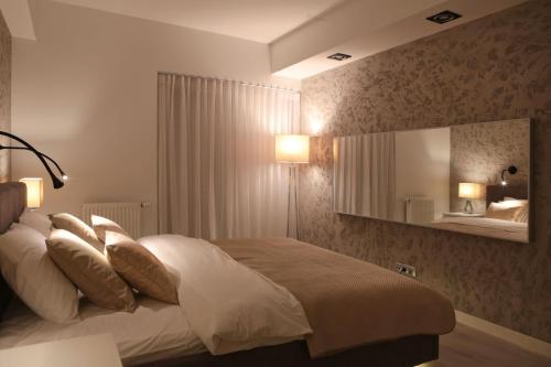 een slaapkamer met een bed met kussens en een spiegel bij Super-Apartamenty VIP in Poznań