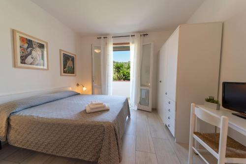 a bedroom with a bed and a television and a window at Residence Hotel Villa Mare in Portoferraio