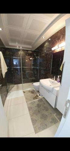 a bathroom with a shower and a toilet and a sink at WEDAT APART On the beach Moda Marine Residence in Alanya