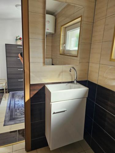 a bathroom with a white sink and a mirror at Apartman Edis i Elma in Visoko