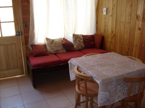 リカンライにあるCabañas Los Castañosのソファ、テーブル、窓が備わる客室です。