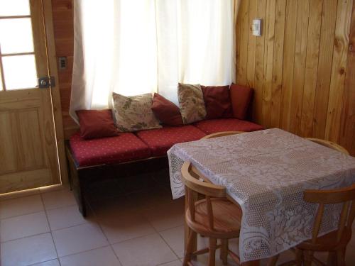 a couch in a room with a table and a window at Cabañas Los Castaños in Licán Ray