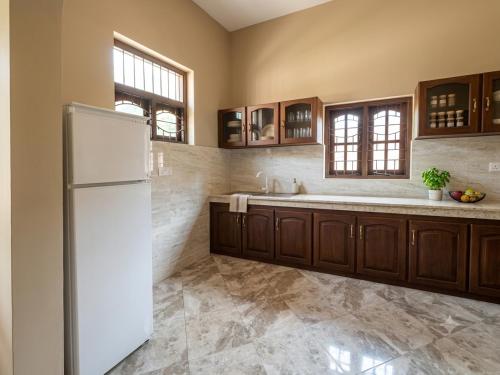 a kitchen with a refrigerator and a sink at DIMORA Bologngna in Chilaw