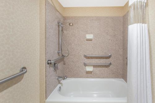 a bathroom with a tub and a shower at Hawthorn Suites Midwest City in Midwest City