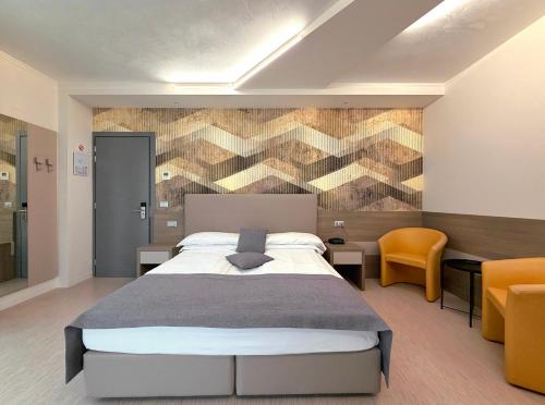 a bedroom with a large bed and a accent wall at Hotel Delle Nazioni - Adults Only in Caorle