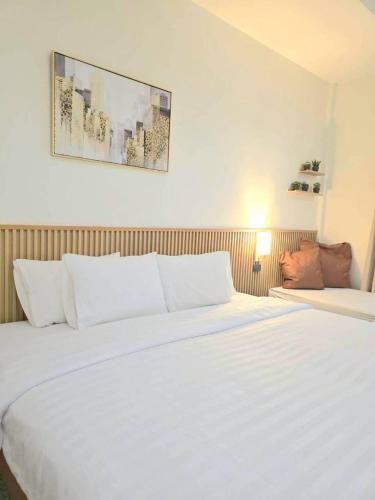 a large white bed in a hotel room at ปราสาทรีสอร์ท in Prasat
