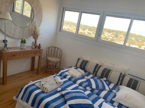 a bedroom with a bed and a desk and windows at Une Chambre privée sur l'Ocean chez l'habitant sur place,espaces partagés, Quiet Luxury in Lacanau