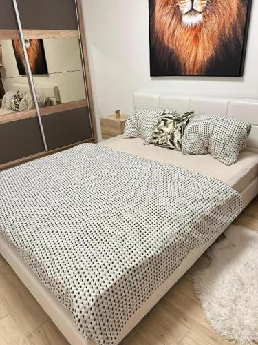 a bed in a room with a picture of a lion at Golf Green Resort - Hesperus 2 in Hrubá Borša