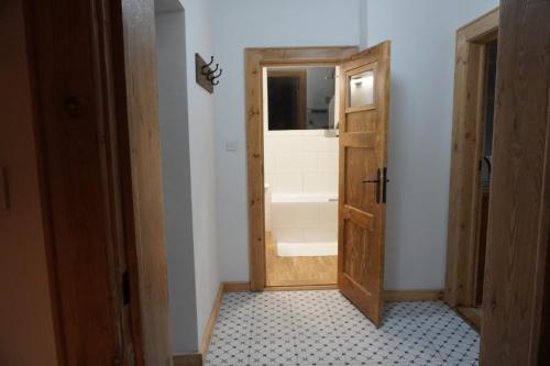 a bathroom with a wooden door and a window at Odpocznij w Gołdapi in Gołdap