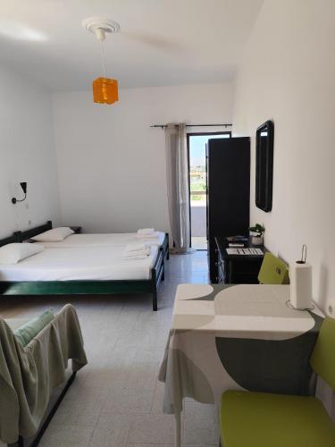 a room with a bed and a table and chairs at Apokoros Craft Deco Apartments & Studios in Kalyves