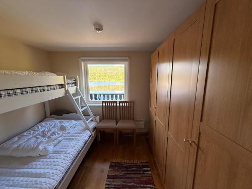 a small bedroom with a bunk bed and a window at Bortelidseter in Åseral