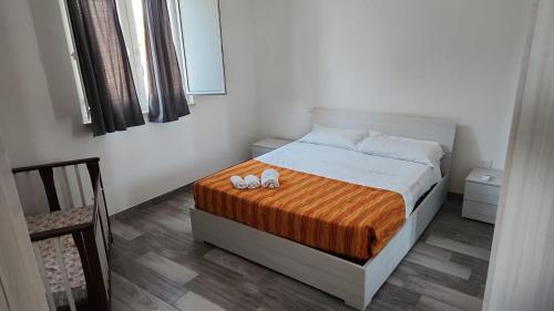 a bedroom with a bed with two slippers on it at Villa Chirilú in Polignano a Mare