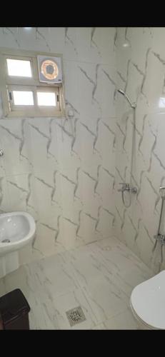 a white bathroom with a sink and a toilet at Highland Residence Al namas in Lahbey