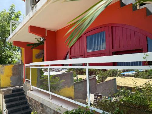 a colorful house with a white railing and stairs at Appartement vu sur mer in Mamoudzou