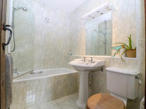 a bathroom with a sink and a tub and a toilet at Tyddyn Iolyn in Benllech