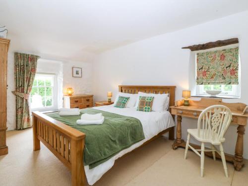 a bedroom with a bed and a desk and a desk at Tyddyn Iolyn in Benllech