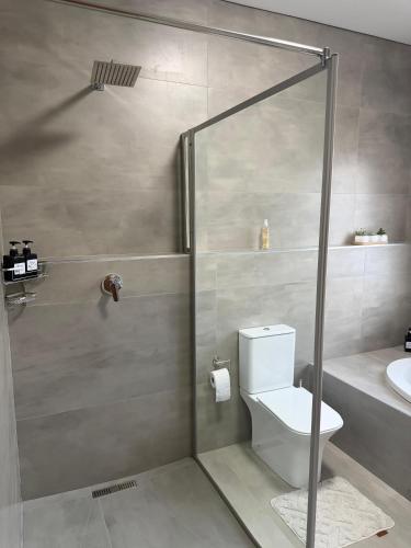 a bathroom with a shower with a toilet and a sink at Natures Nest with Mongi Hazyview in Hazyview