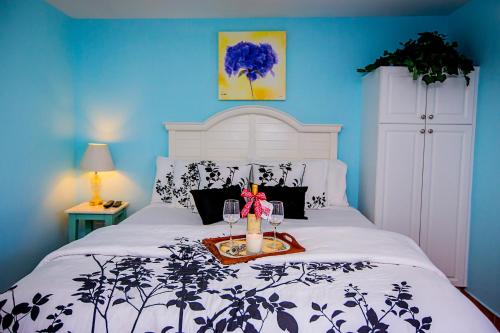 a bed with two glasses and a tray on it at Leucadia Beach Inn in Encinitas