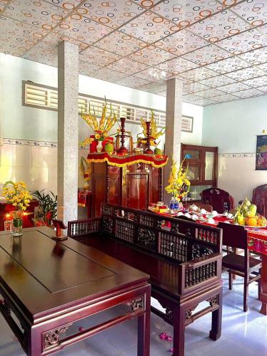 a living room with a table and a dining room at Que Nha Homestay in Ấp Chợ (2)