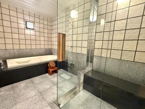 a bathroom with a tub and a toilet and a shower at Hotel Shuyukan (Adult Only) in Izumi-Sano