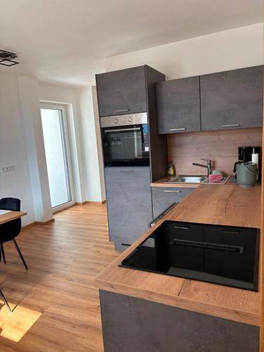a kitchen with stainless steel appliances and a wooden counter top at FEWO-TomKO in Fügenberg