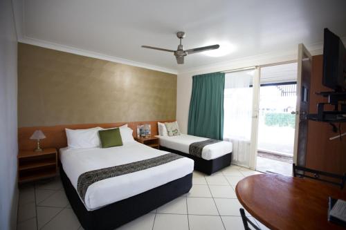 
a hotel room with two beds and a large window at David Motor Inn in Rockhampton
