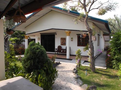 a small white house with a porch at Ryans Resort in Prasat
