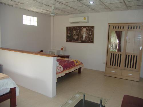 a bedroom with a bed and a cabinet in it at Ryans Resort in Prasat