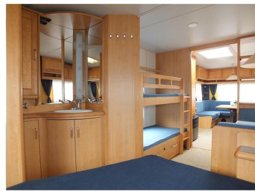 a small room with a bunk bed and a kitchen at Hobby 750 caravan in Oslo