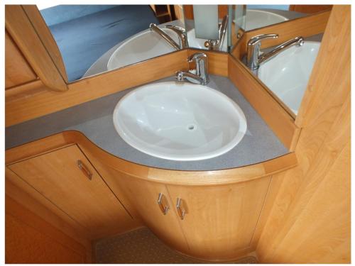a bathroom with a sink and two mirrors at Hobby 750 caravan in Oslo